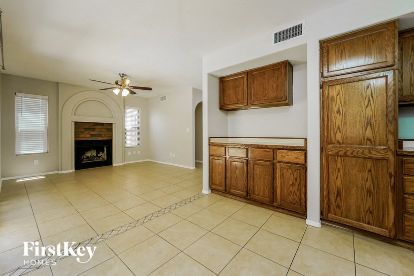 a kitchen and living room with a fireplace and wooden cabinets