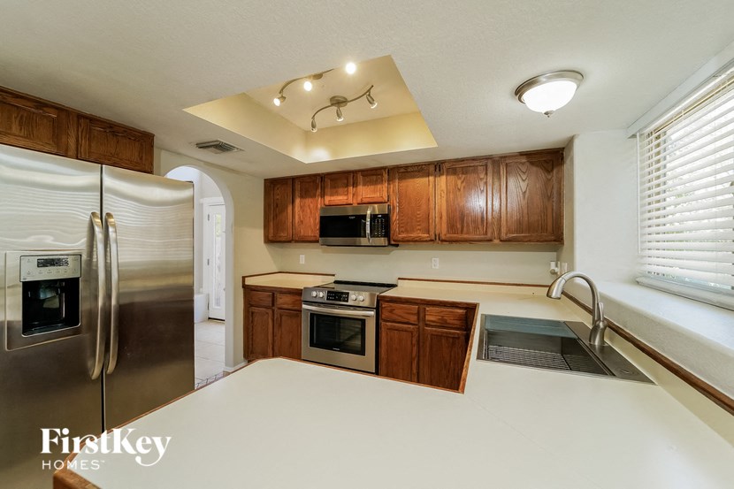 a kitchen with wooden cabinets and stainless steel appliances