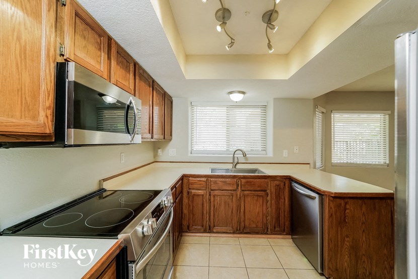 a kitchen with wooden cabinets and a stove and a microwave