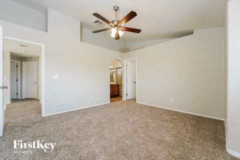 a spacious living room with a ceiling fan and carpet
