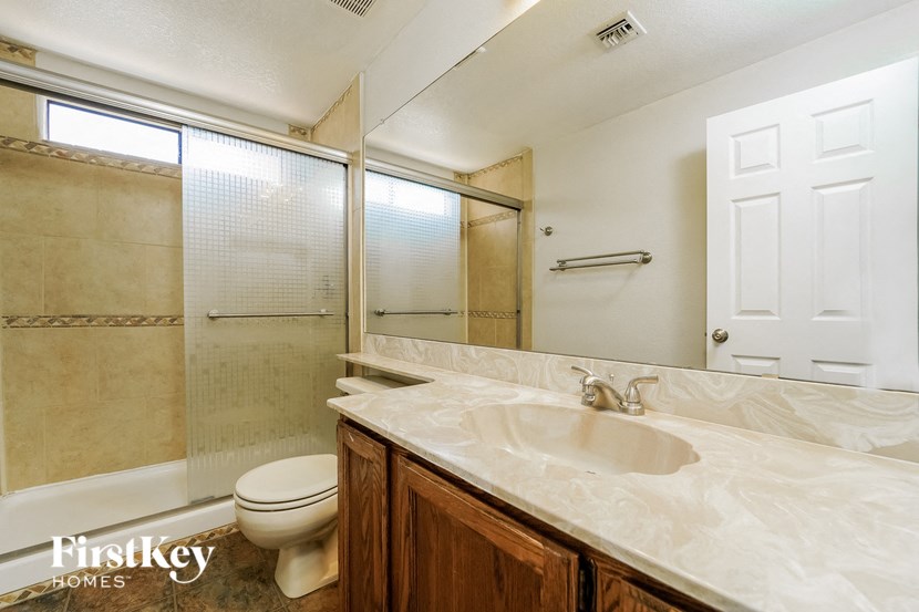 a bathroom with a toilet and a sink and a shower