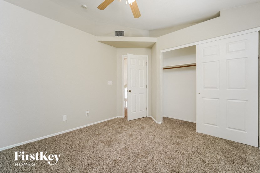 a bedroom with two closets and a ceiling fan