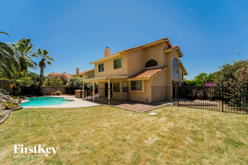 a backyard with a pool and a house with a fence