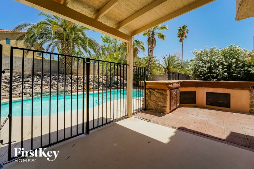 a swimming pool is next to a house with a fence
