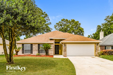 a suburban house with a lawn and trees