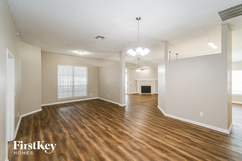 the living room and dining room with hardwood flooring and a fireplace