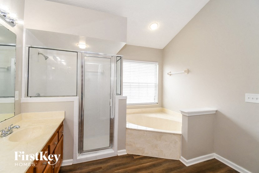 a bathroom with a tub and a shower and a sink