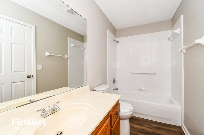 a bathroom with a white tub and a sink and a toilet