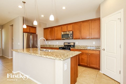 A kitchen with wooden cabinets and granite countertops.