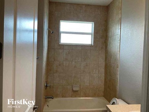 a bathroom with a bath tub and a window