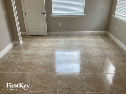 an empty room with a tile floor and a door