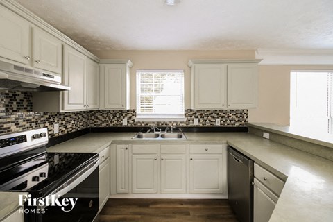 A kitchen with a stove top oven and a sink.