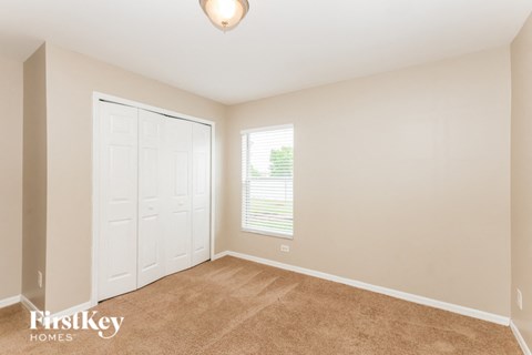 a bedroom with a closet and a door and a window