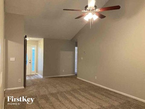 an empty living room with a ceiling fan