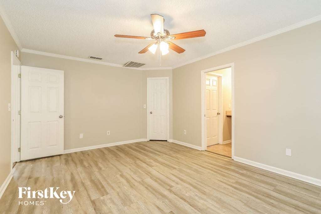 a spacious living room with wood flooring and a ceiling fan