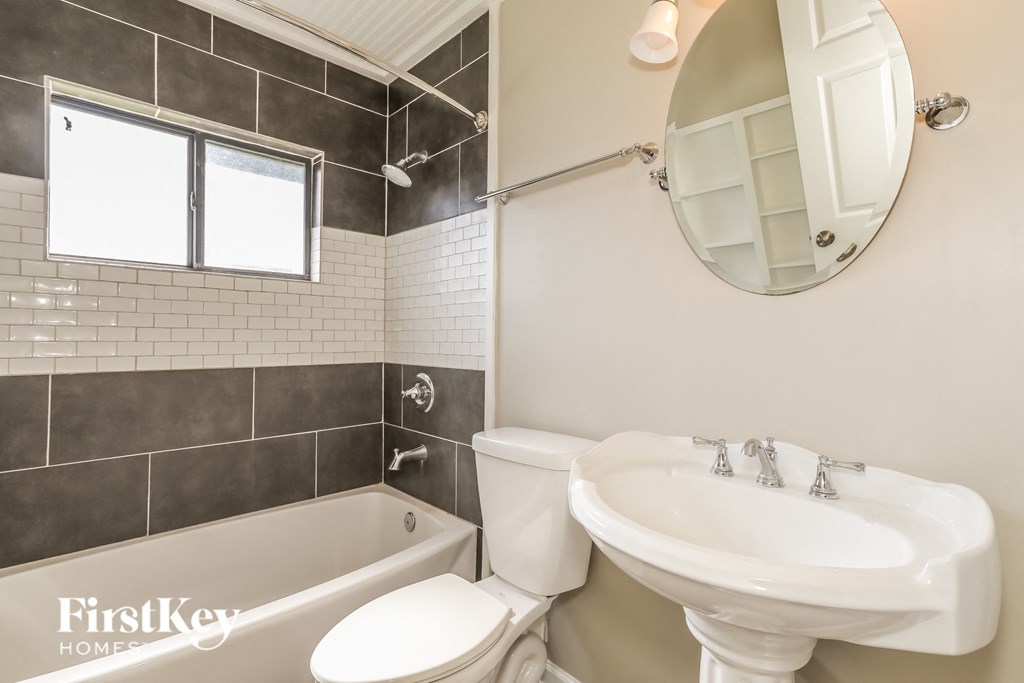 a white bathroom with a sink toilet and bath tub