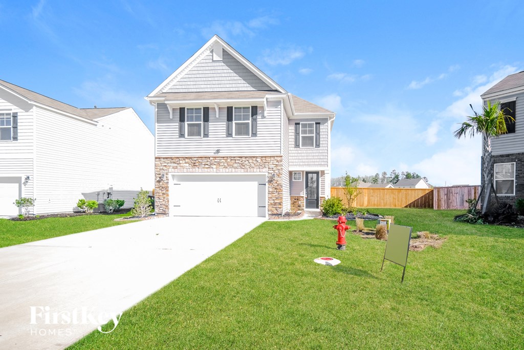 A house with a white garage door and a red fire hydrant in the front yard.