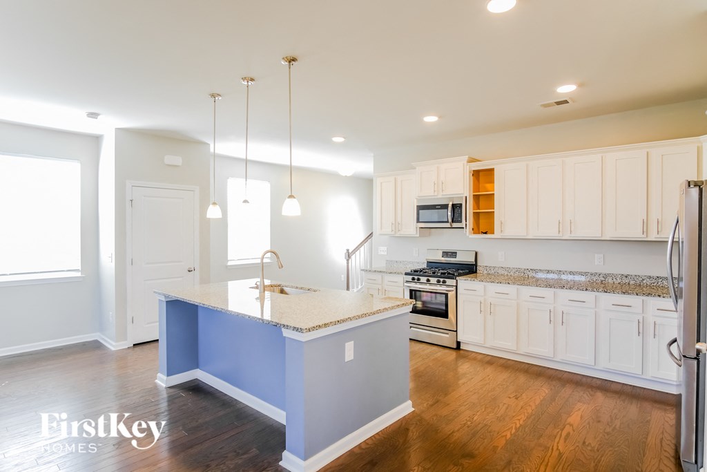 A kitchen with a blue island and wooden cabinets.