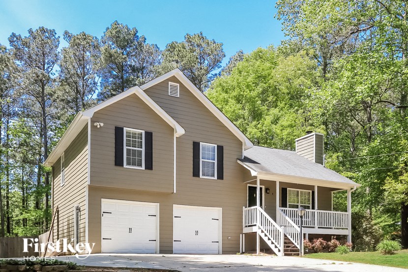 A two-story house with a garage and a balcony.