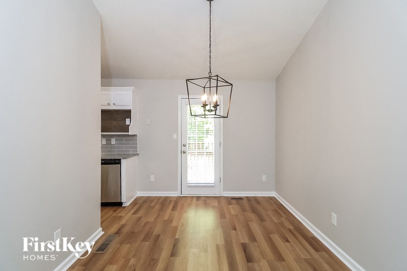 A well lit room with wooden floors and a chandelier hanging from the ceiling.