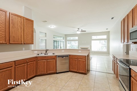 a large kitchen with wooden cabinets and a stainless steel dishwasher