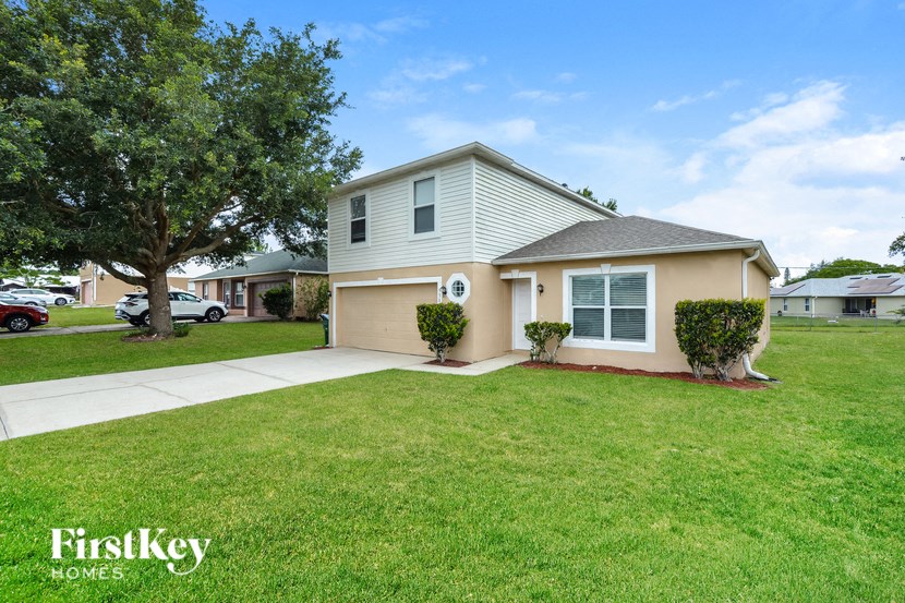 a home with a lawn and a sidewalk in front of it