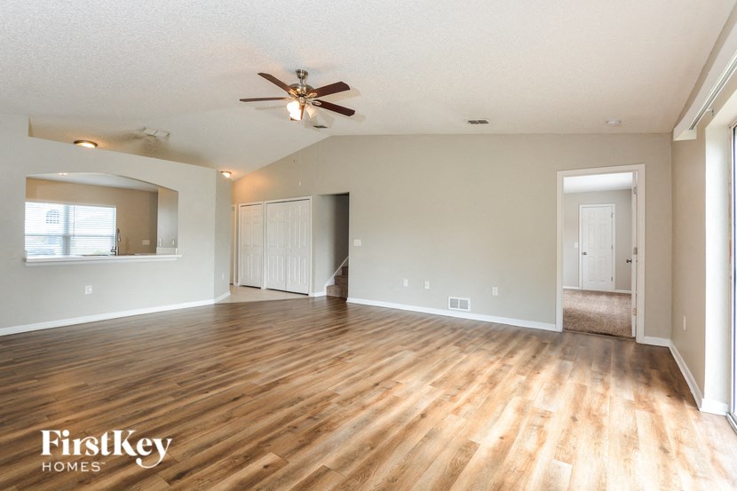 a living room with wood flooring and a ceiling fan