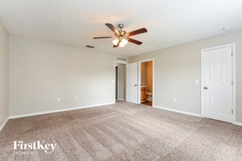 a living room with carpet and a ceiling fan