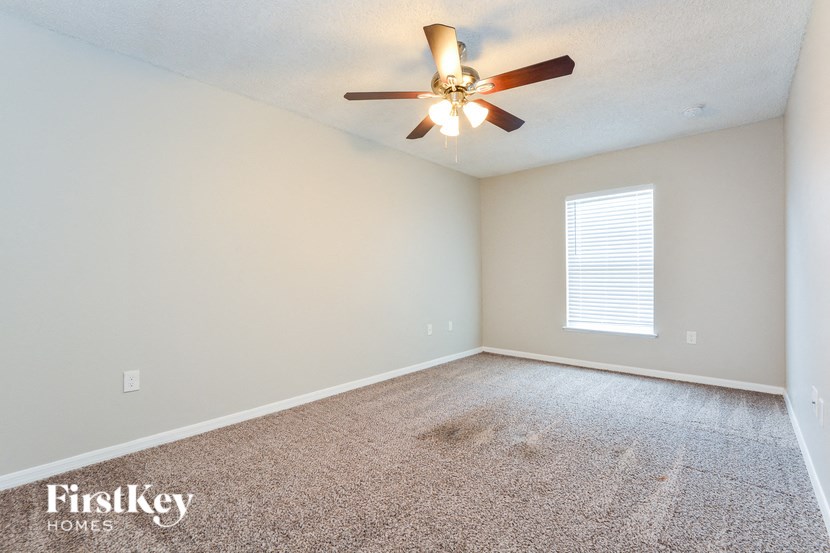 an empty living room with a ceiling fan