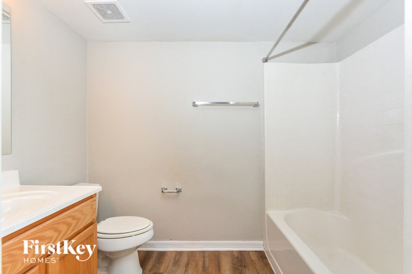 a bathroom with a toilet and a tub and a sink