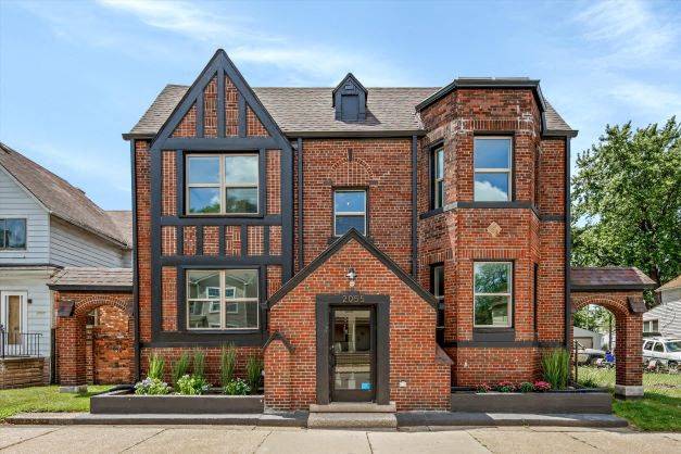 a red brick house with a black roof