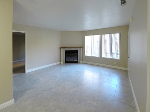 A spacious living room with a fireplace and a television.