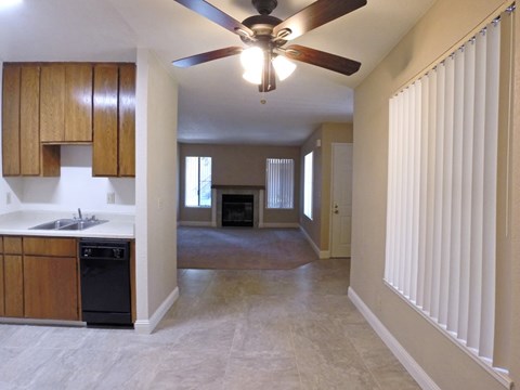 A kitchen with wooden cabinets and a black dishwasher.
