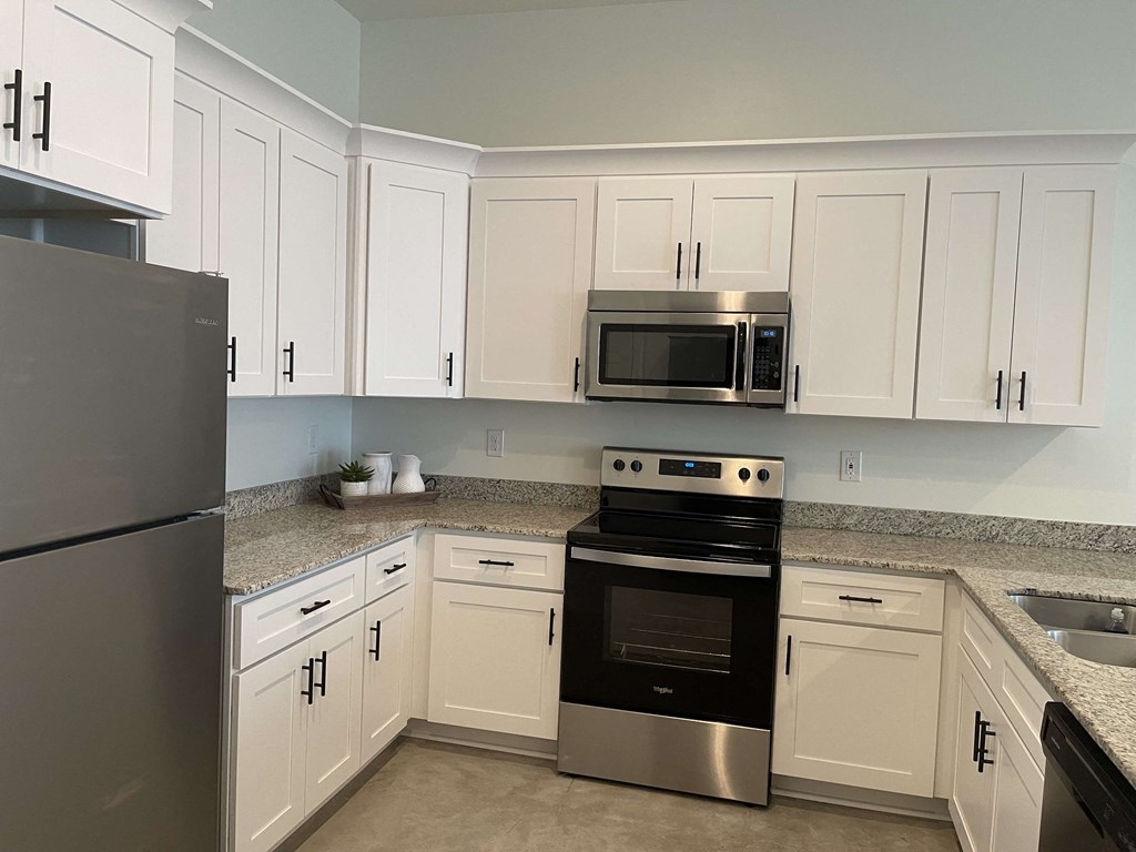 a kitchen with stainless steel appliances and white cabinets