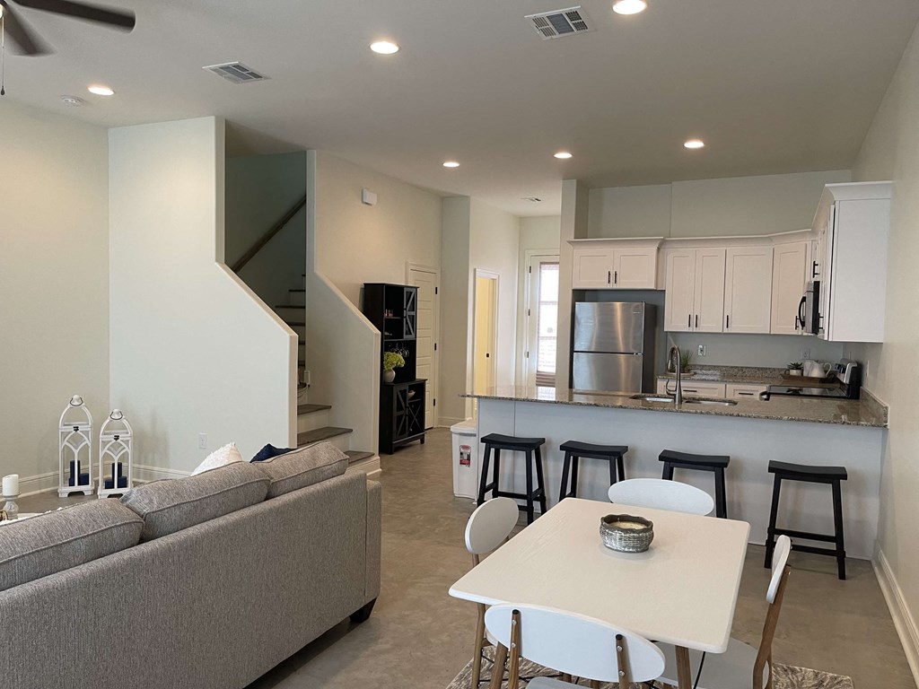 a living room and kitchen with a couch and a table