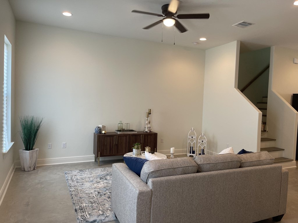 a living room with a couch and a ceiling fan
