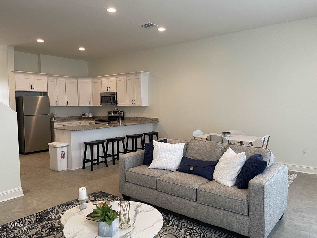 a living room and kitchen with a couch and a table