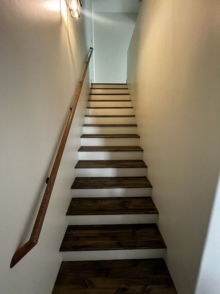 a set of stairs with wooden treads and white walls