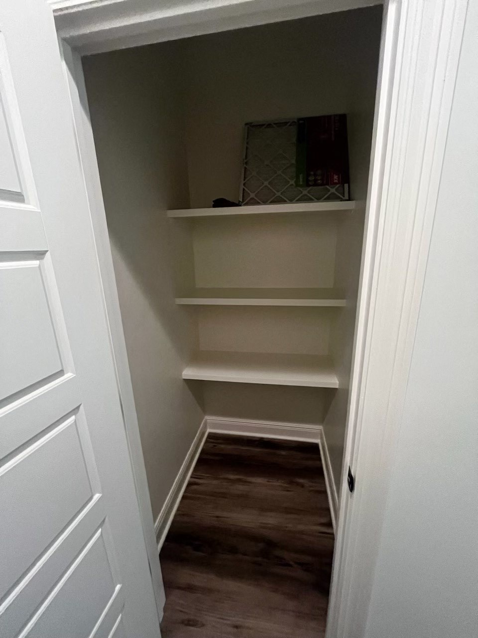 a walk in closet with shelves and a mirror