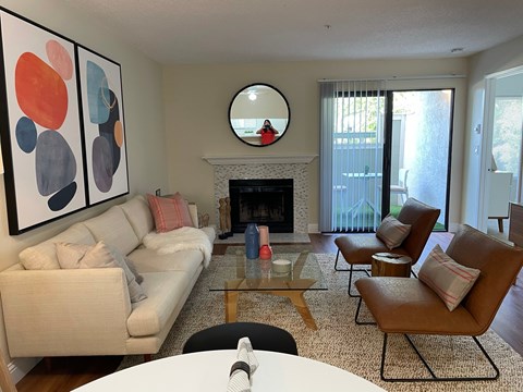 A living room with a fireplace and a painting on the wall.