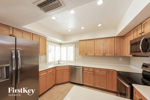 A kitchen with wooden cabinets and a stainless steel refrigerator.