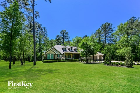 A house with a lawn and trees in the background.