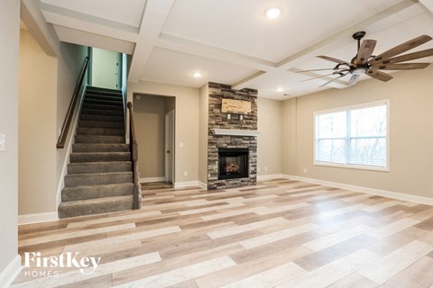 the living room has a fireplace and a staircase to the second floor