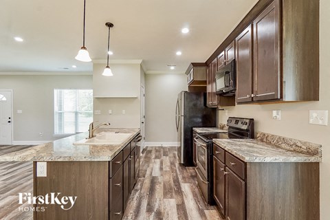 A kitchen with wooden cabinets and a black refrigerator.