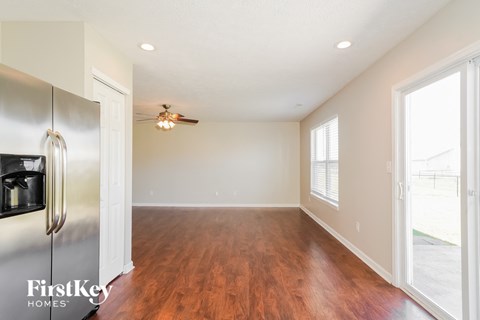 A kitchen with a stainless steel refrigerator and wooden floors.