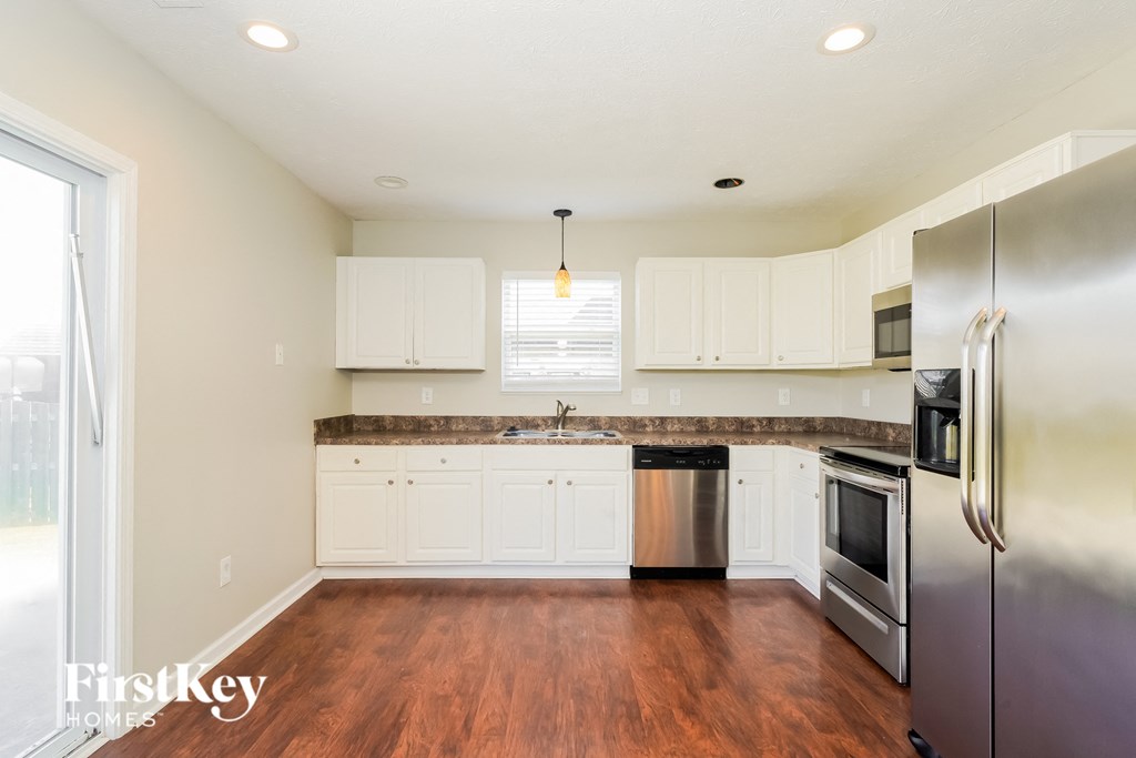 A kitchen with wooden floors and stainless steel appliances.