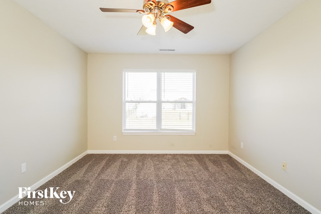A room with a ceiling fan and a window.