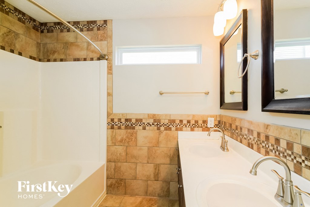 A bathroom with a tiled shower and a sink.