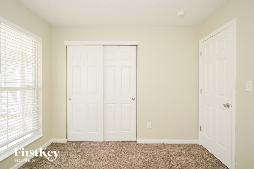 A room with a carpeted floor and a white door.