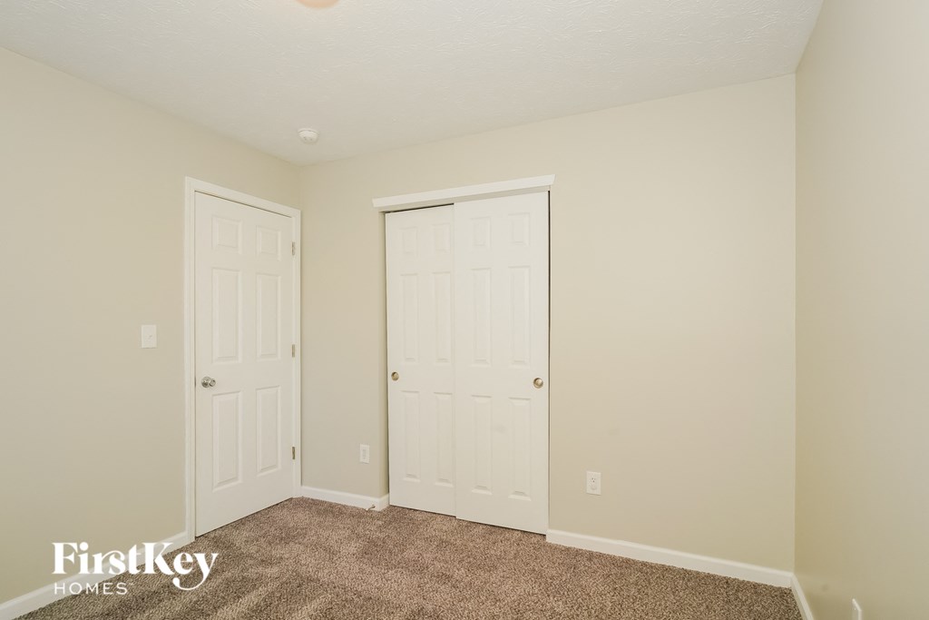 A room with two doors and a carpeted floor.